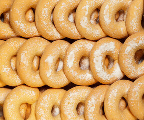 Donuts with powder suger in a row. Background. Top view.