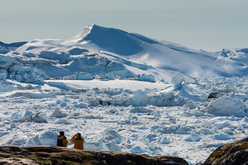Greenland. Ilulissat. Visitors taking in the expanse of the Icefjord.