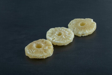 Dried pineapple slices on a dark background
