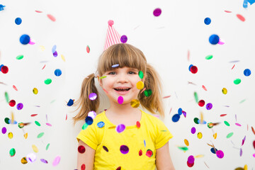 happy child girl with confetti on white background
