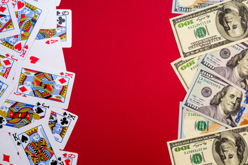 American dollars banknotes with playing cards on red background with copy space. Game addiction. Gambling, casino