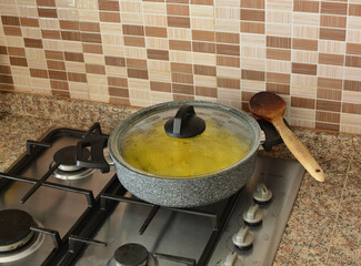 a meal cooked in a granite pot on the gas stove.wooden spoon on the pot.