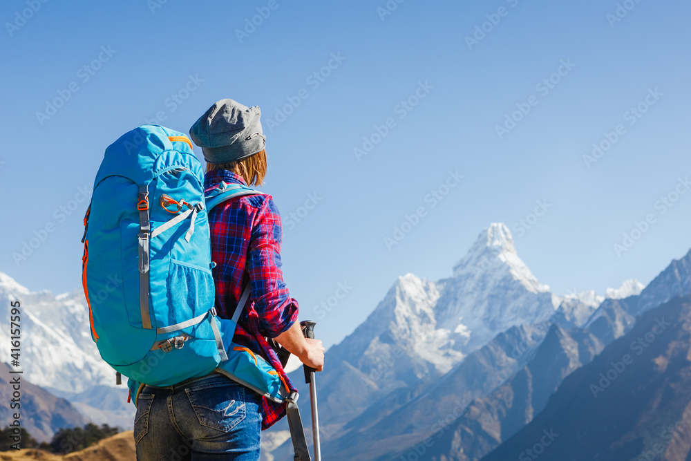 Wall mural Woman Traveler with Backpack hiking in Mountains with beautiful Himalaya landscape on background mountaineering sport lifestyle concept