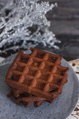 Traditional Belgian waffles with cocoa on wooden background, homemade healthy breakfast.