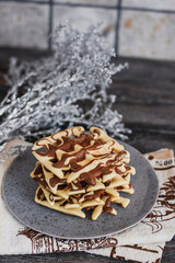 Traditional Belgian waffles with cocoa on wooden background, homemade healthy breakfast.