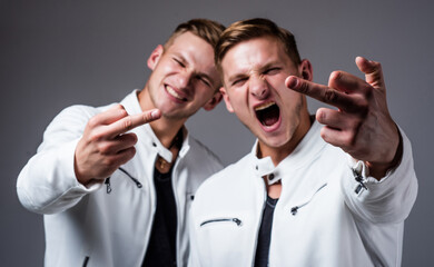 two cousin show middle finger. young confident brothers. confident fashion models