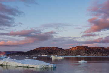 Greenland. Disko Bay. Sunset with icebergs and the arid coast of Greenland.