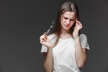 Obraz premium Exhausted young woman touching her head with eyes closed. girl is suffering from unbearable headache. Health concept. Negative human emotions, headache face expressions. depression stressed tired.