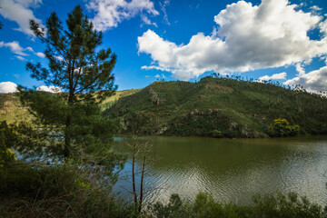 Fototapeta na wymiar Landscape view of the lake with mountains background and beautiful clouds on the sky. Landscape view of Zezere river in Aldeias de Xisto, Portugal