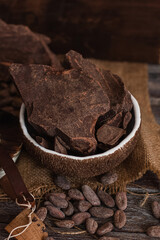 Unsweetened baking block chocolate, cocoa powder, cocoa butter and cocoa beans on old wooden background