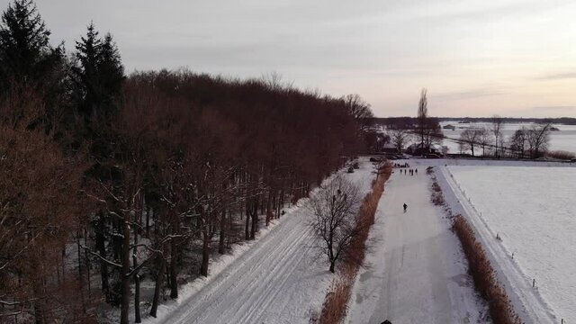 Aerial shot, Dutch winter landscape, ice skating on frozen river