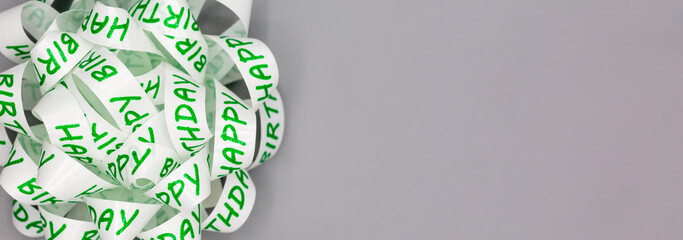 White gift ribbon knotted together with inscription happy birthday as background for web design,...