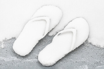 Forgotten flip flops in the snow. Unexpected weather concept.