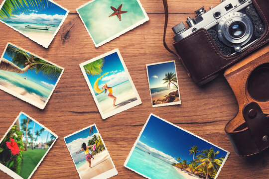 Vintage retro camera with travel photos on wooden background