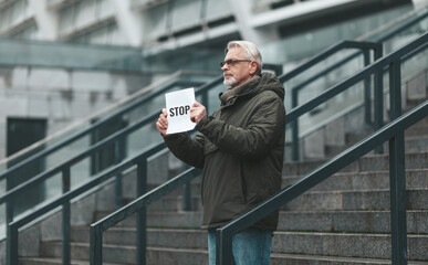 Senior man protests near the court. Single picket.