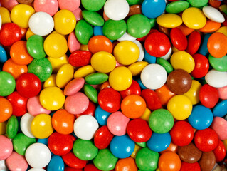 Fototapeta na wymiar Bright colorfull background with glazed round candy M&M's.