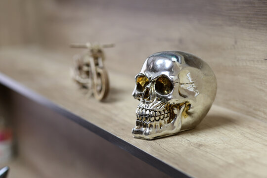 silver skull on wooden motorcycle background