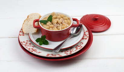 Chickpea casserole presented in table service in red and white color on wooden background