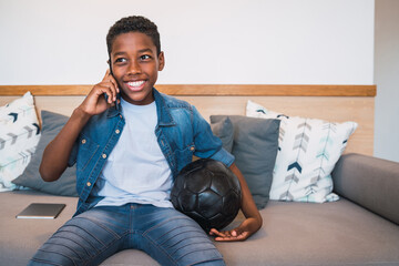 Little boy talking on the phone at home. © Mego-studio