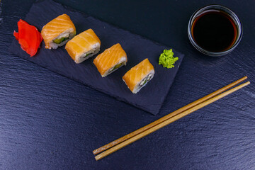 Sushi rolls Philadelphia on a black slate. Top view