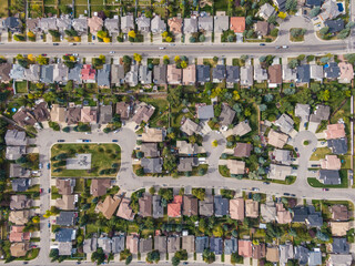 Aerial top down view of houses and streets in residential neighbourhood during fall season in Calgary, Alberta, Canada.
