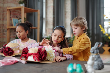 Children decorating hats with flowers