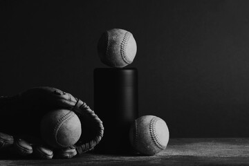 Dark and moody still life with baseball equipment in black and white, sports nostalgia with copy space on background.