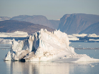 Iceberg in the Uummannaq Fjord System. Glaciated Nuussuaq peninsula in the background. Greenland,...
