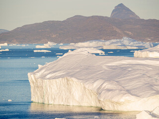 Iceberg in the Uummannaq Fjord System. Glaciated Nuussuaq peninsula in the background. Greenland,...