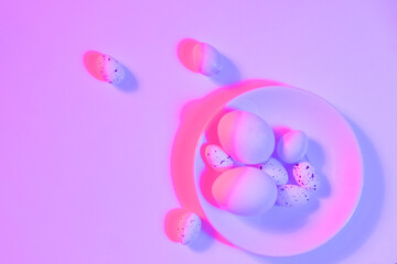 White Easter eggs with colorful ultraviolet holographic neon lights. Creative concept.