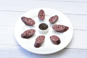 Morcilla Antioqueña, traditional Colombian sausage, covered with lemon and pepper on wooden...