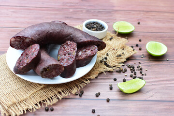 Morcilla Antioqueña, traditional Colombian sausage, covered with lemon and pepper on wooden...