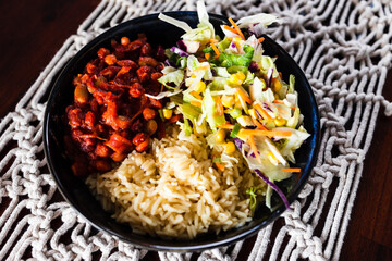 healthy plant-based food, vegan nourish bowl with bean chilli sauce, rice and Mexican coleslaw salad mix