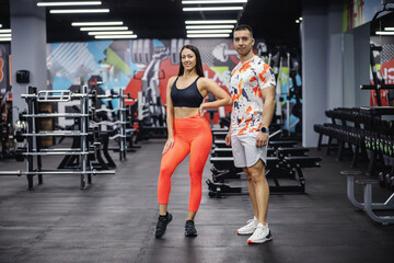 Couple in shape standing in gym and posing. Healthy life, bodybuilding