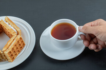 A cup of aroma tea with delicious waffles
