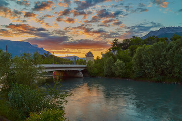 Obraz premium View over the river Isere to the Porte de France with the most beautiful evening sky. 
