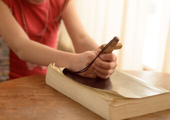 teenager girl praying to God holding a wooden cross,focus on cross.Concept of faith,hope and love