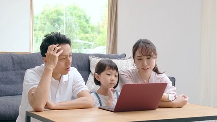 パソコンを見ながら悩む家族