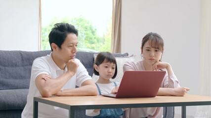 パソコンを見ながら悩む家族