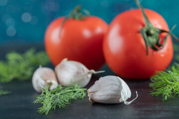 Fresh tomatoes with garlic on a dark background