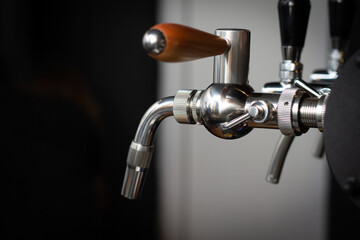 Partially blurred silvery bar beer taps in pub