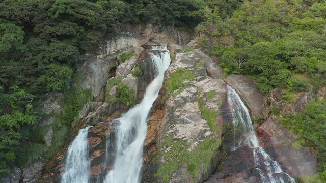 Oko Falls in Yakushima, Flowing over mountainside forest, Pan Shot, Japan