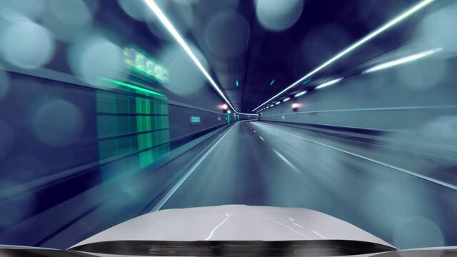 Driving fast through a tunnel by car in drivers view in the Tenet film look, while rain drops are reflecting the night lights at the cars front window