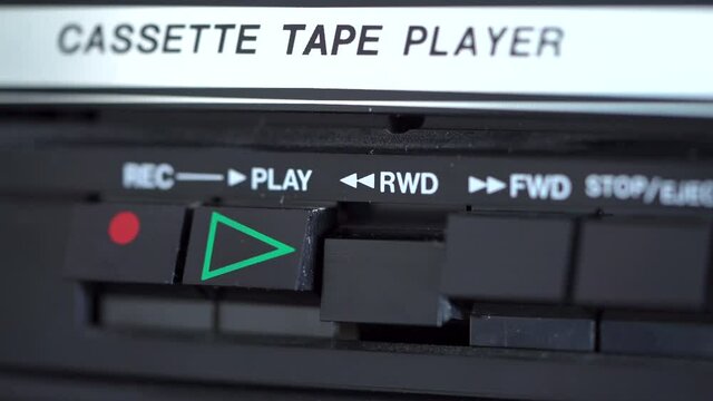 Rewind button being pressed on a vintage retro cassette tape player 4K