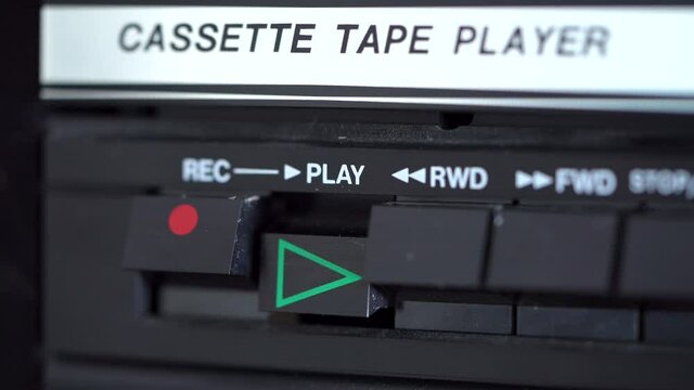 Play button being pressed by a male hand on a vintage retro cassette tape player. 4K