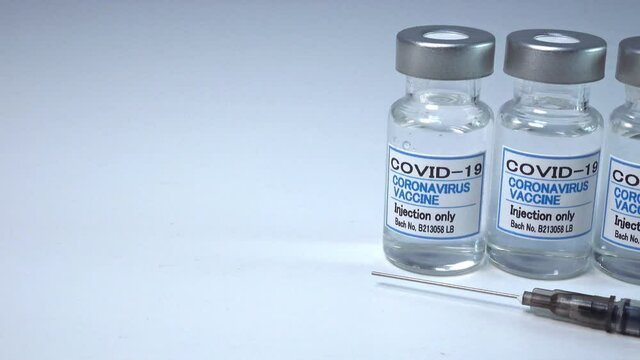 注射器とCOVIC-19(新型コロナウィルス)用ワクチンのイメージをパン