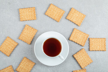 Aroma cup of tea with tasty crackers on a wooden table