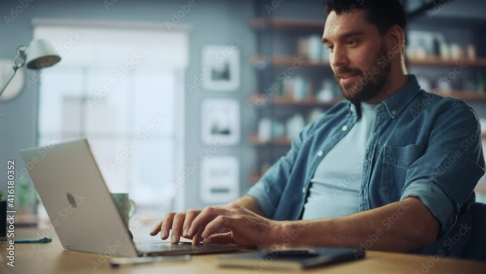 Aufkleber handsome caucasian man working on laptop computer while sitting on a sofa couch in stylish cozy livi