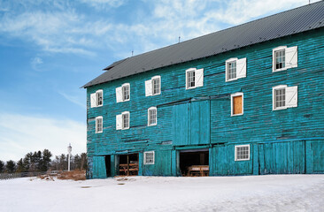 View of a blue wooden barn under snow after a winter storm in New Jersey