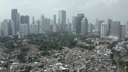 Tilt down onto neighborhood and apartment building from Jakarta city skyline